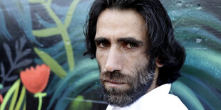 Autor Behrouz Boochani guckt ernst in die Kamera