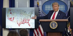 US-Präsident Donald Trump zeigt eine US-Karte, auf der die Schwerpunkte der Corona-Infektionen markiert sind