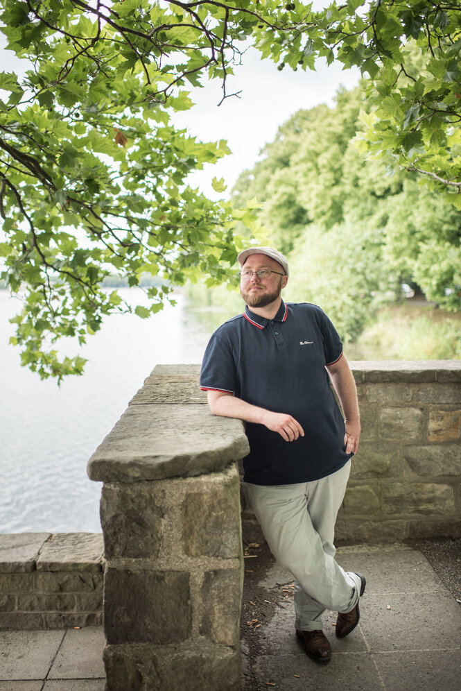 Transmann Till Randolf Amelung steht mit einer Mütze vor an einer Mauer am Maschsee in Hannover