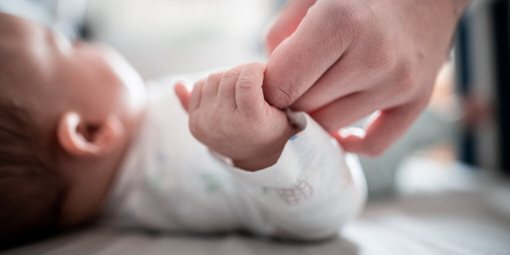 Eine Hand hält eine Babyhand