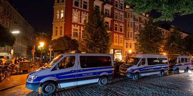 Drei Einsatzfahrzeuge der Polizei im nächtlichen Hamburger Schanzenviertel