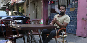 Ein arbeitsloser Libanese sitzt in einem Straßencafe und raucht Wasserpfeife