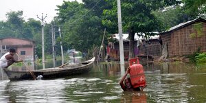 Bewohner bahnen sich ihren Weg durch das Hochwasser in einem Dorf im ostindischen Bundesstaat Bihar. Dem Katastrophenschutz zufolge sind durch starke Gewitter über ein Dutzend Menschen ums Leben gekommen.