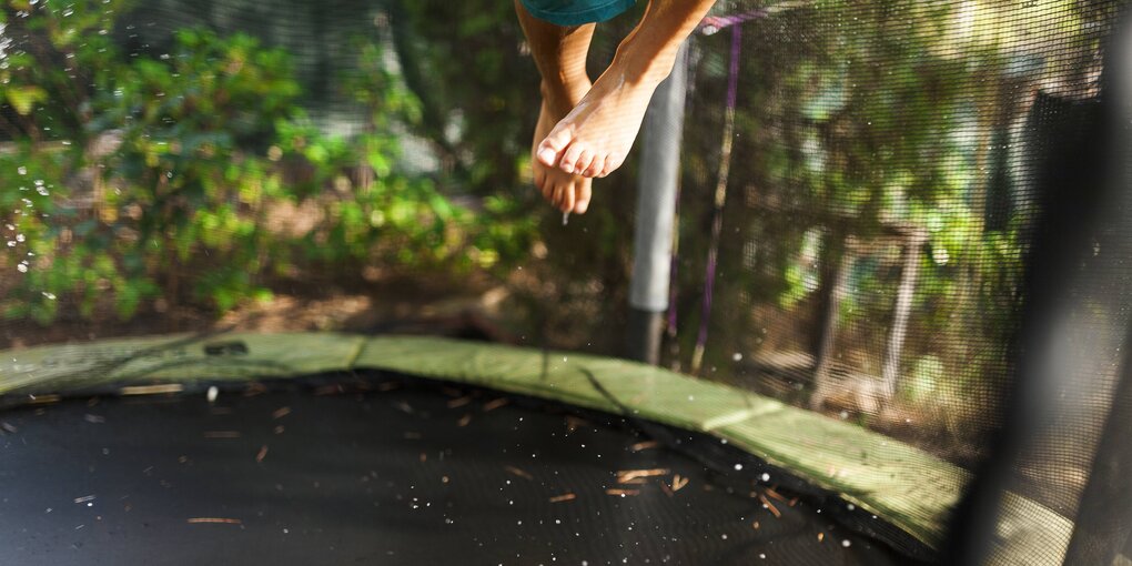 Ein Kind auf einem Trampolin springt aus dem Bild