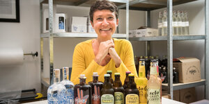 Andrea Stenz, Gründerin des Limonadenherstellers, sitzt vor vielen Flaschen