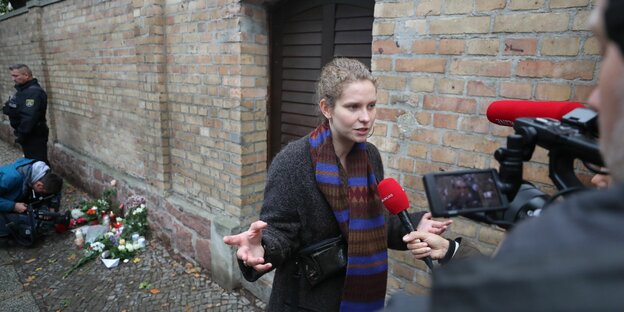 Christina Feist gibt vor der Synagoge in Halle ein Interview.