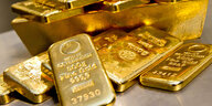 Goldbarren in unterschiedlicher Größe liegen bei einem Goldhändler in einem Tresor