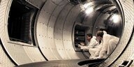 Zwei Männer in weissen Schutzanzügen arbeiten am ITER