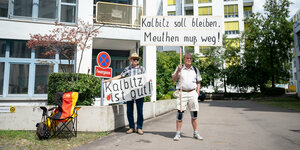Zwei Männer halten Schilder mit der Aufschrift "Kalbitz soll bleiben, Meuthen muss weg!" und "Kalbitz ist gut"