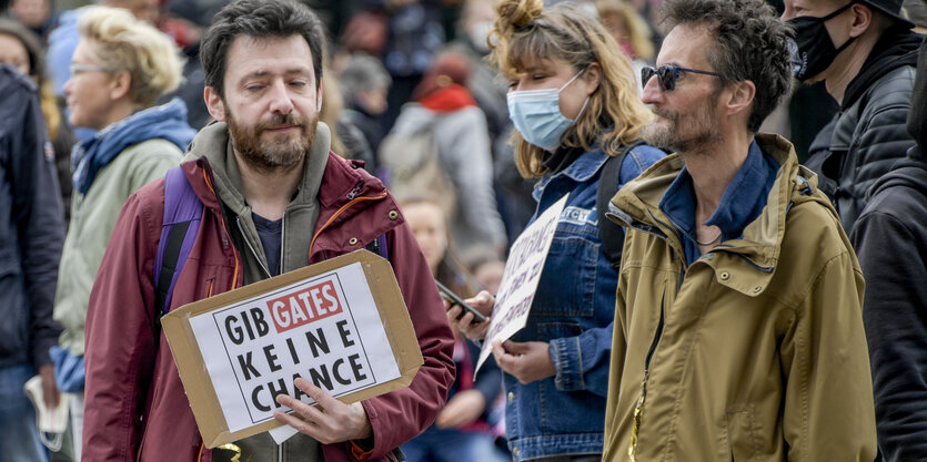 2 Demonstranten. Einer trägt ein "Gib Gates keine Chance"-Schild