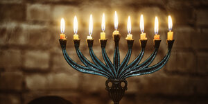 Ein Chanukkia-Leuchter mit brennende Kerzen