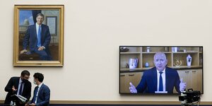 Jeff Bezos mit angespanntem Blick ist auf einem Bildschirm im Repräsentantenhaus zu sehen