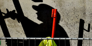 Schatten eines Bauarbeiters auf Beton