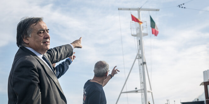 Mann deutet auf Schiff