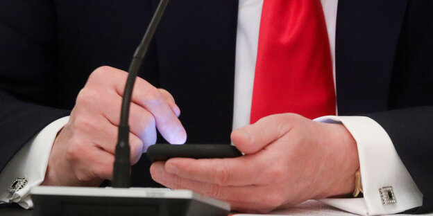 Die Hände des US-Präsidenten an einem Smartphone