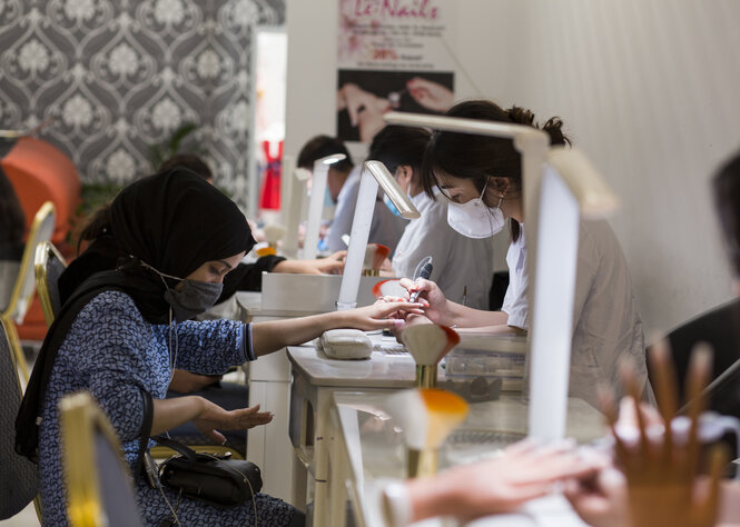 In einem Nagelstudio, das als Ausbildungszentrum dient, wird an meheren Plätzen gearbeitet