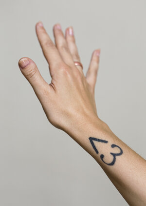 Der Unterarm von Anne Helm mit einem Tattoo: ein Winkel und eine "3" ergeben eie Herzform Der Unterarm von Anne Helm mit einem Tattoo: ein Winkel und eine "3" ergeben eie Herzform