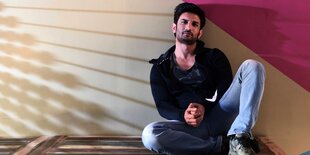 Der Schauspieler Sushant Singh Rajput sitzt auf einer Kiste und schaut in die Kamera