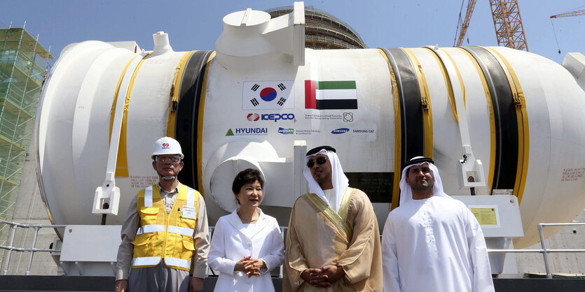 Die ehemalige Präsidentin von Südkore Park Geun-hye steht in Barakah während einer Zeremonie mit anderen Menschen vor einem Teil des Kernreaktors.