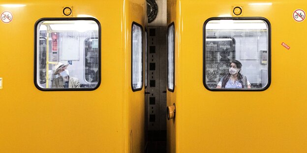Zwei Menschen mit Maske in einer Berliner U-Bahn
