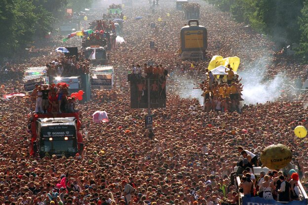 Eine Masse tanzender Raver, dazwischen Trucks Eine Masse tanzender Raver, dazwischen Trucks