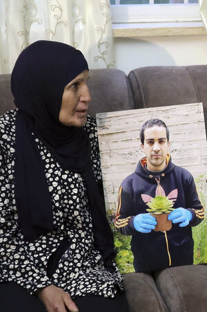Eine Frau posiert mit einem Bild eines jungen Mannes. Eine Frau posiert mit einem Bild eines jungen Mannes.