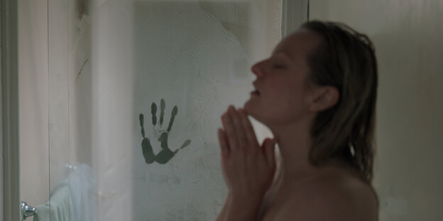 Frau unter der Dusche, mit Handabdruck an der Scheibe