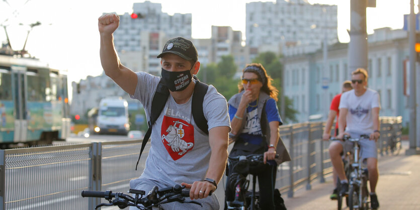 Ein Mann auf einem Fahrrad reckt die Faust