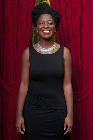 Die ghanesische Autorin Yaa Gyasi lächelt für ein Porträt vor purpurfarbenem Vorhang. Die ghanesische Autorin Yaa Gyasi lächelt für ein Porträt vor purpurfarbenem Vorhang.