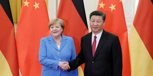 Merkel und Xi Jinping posieren vor Flaggen