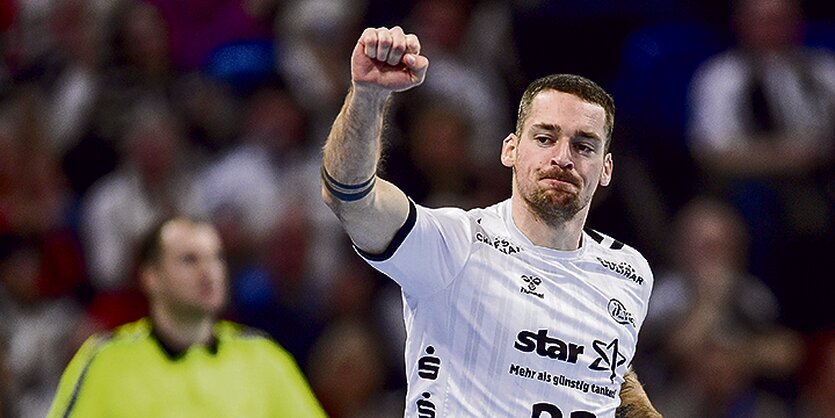 Der Handball-Spieler Ole Rahmel jubelt mit ausgestreckter Faust.