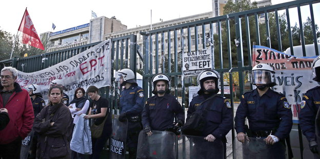 Polizisten und Demonstranten stehen im Jahr 2013 vor dem Gebäude des griechischen Staatssenders ERT.