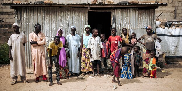 Eine Großfamilie steht vor ihrer Unterkunft in Kamerun