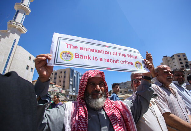 in Teilnehmer einer Demonstration gegen Israels Annexionsplan hält ein Plakat mit der Aufschrift "The annexion of the West Bank is a racist crime" in Teilnehmer einer Demonstration gegen Israels Annexionsplan hält ein Plakat mit der Aufschrift "The annexion of the West Bank is a racist crime"