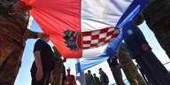 Eine kroatische Flagge wird bei Feierlichkeiten von Männern gehalten