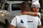 Ein Mann trägt nach einer Explosion im Hafen von Beirut ein verletztes Kind.