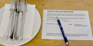 Ein Zettel für die Gäste-Regstrierung liegt in einem Restaurant auf einem Tisch.