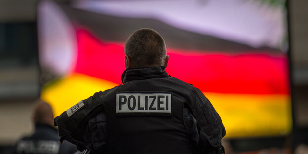 Polizist vor Deutschlandfahne
