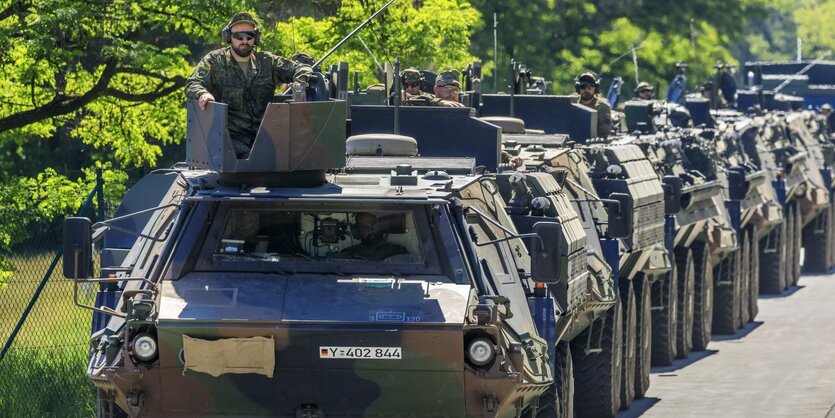 Eine Kolonne von Panzern fährt auf einer Straße