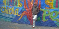 Der kolumbianische Autor Pedro Badrán steht an eine mit Graffiti verzierte Mauer gelehnt.