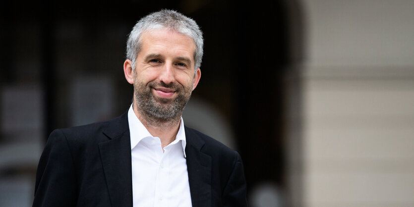 Tübingens Oberbürgermeister boris palmer steht vor dem Rathaus und grinst