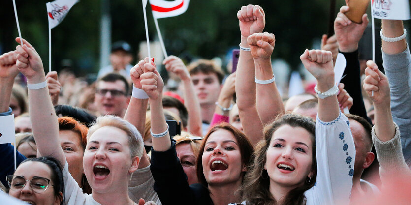 Viele Menschen, vor allem Frauen, jubeln bei einer Wahlveranstaltung und strecken ihre Fäuste in die Luft