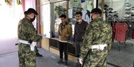 Serbische Militärpolizei überprüft Geflüchtete vor einem Sportgeschäft