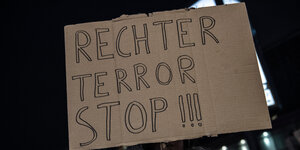 Menschen demonstrieren am Hermannplatz in Neukölln gegen rechten Terror. Ein Mann hält ein Schild hoch, auf dem steht: Rechter Terror stoppen!