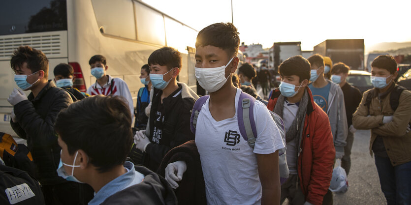 Eine Gruppe unbegleiteter Kinder aus überfüllten griechischen Flüchtlingslagern tragen Schutzmasken, während sie mit einer Fähre im Hafen von Piräus ankommen