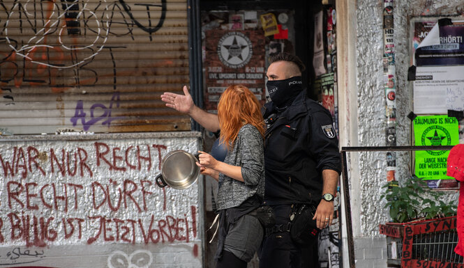 Ein Polizist und eine Demonstrantin vor dem Syndikat