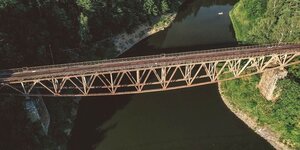 rostige Stahlbrücke über einem Fluss