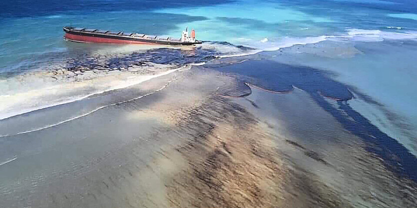 Ein Schiff im Meer aus dem sichtbar Öl ausläuft