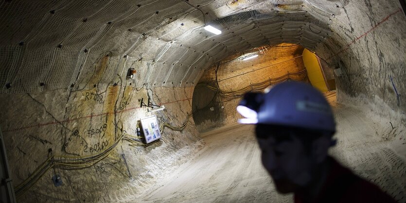 Ein Mann mit Helm und Grubenlampe steht im Stollen des Erkundungsbergwerks Gorleben