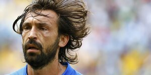 Der Fußballer Andrea Prlo verschwitzt in Nahaufnahme. Er hat einen dichten Bart und lange Haare, die im Wind fliegen.